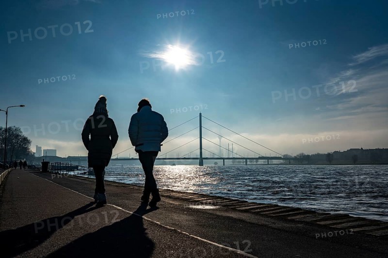 Dense fog is slowly lifting, riverside promenade on the Rhine near Düsseldorf, in front the Oberkassler Bridge, behind it the Rheinknie Bridge, North Rhine-Westphalia, Germany, Europe