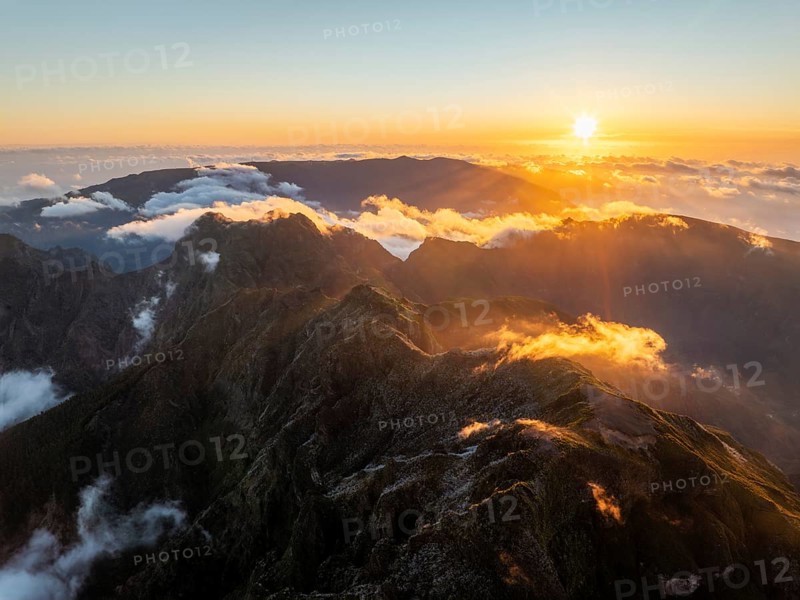 Aerial drone view of mountains over clouds near Pico Ruivo on sunset. Madeira island, Portugal, Europe