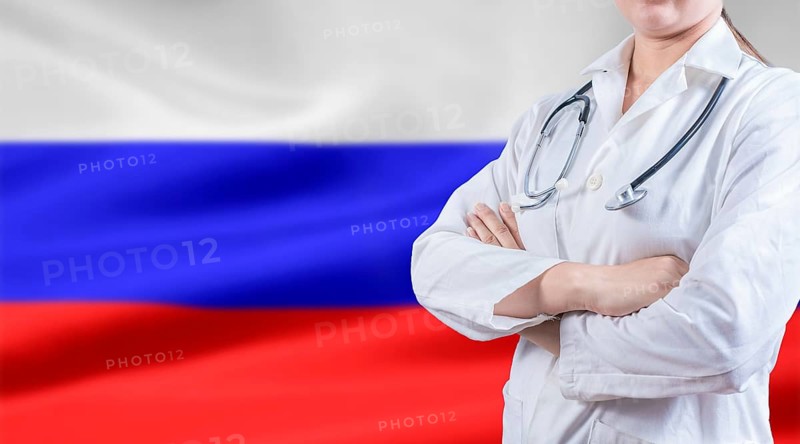 Doctor with stethoscope on Russian flag. Russian health and care concept. Doctor with crossed arms on flag of Russian Federation