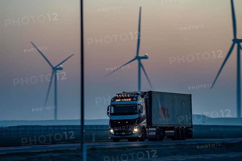 Lorry on the road to Euromax Terminal Rotterdam, ENECO wind farm on the dike around the port of Maasvlakte 2, 22 wind turbines with a capacity of 116 megawatts, sunset, Rotterdam, Netherlands