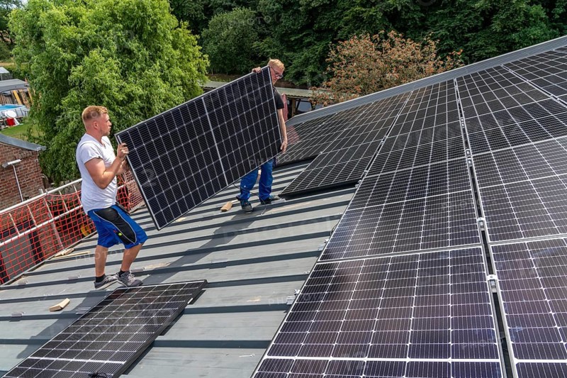 Installation of solar modules on the roof of a barn on a farm, over 210 photovoltaic modules are installed on the roof, North Rhine-Westphalia, Germany, Europe