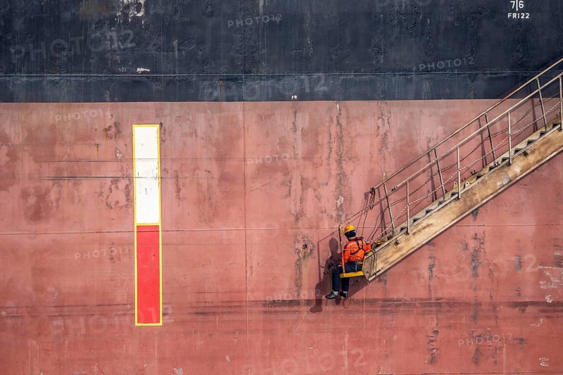 Sailor, waiting, on a leash, for the pilot, on a companionway, drop deck, ship's stairs, cargo ship in the harbour of Rotterdam, Netherlands