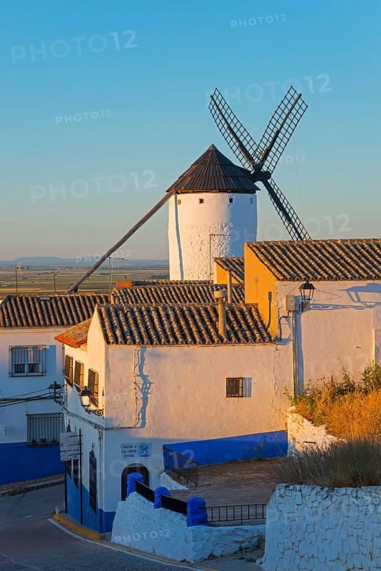 Windmill behind houses in a small village, illuminated by the morning sun, Campo de Criptana, Ciudad Real province, Castilla-La Mancha, Route of Don Quixote, Spain, Europe