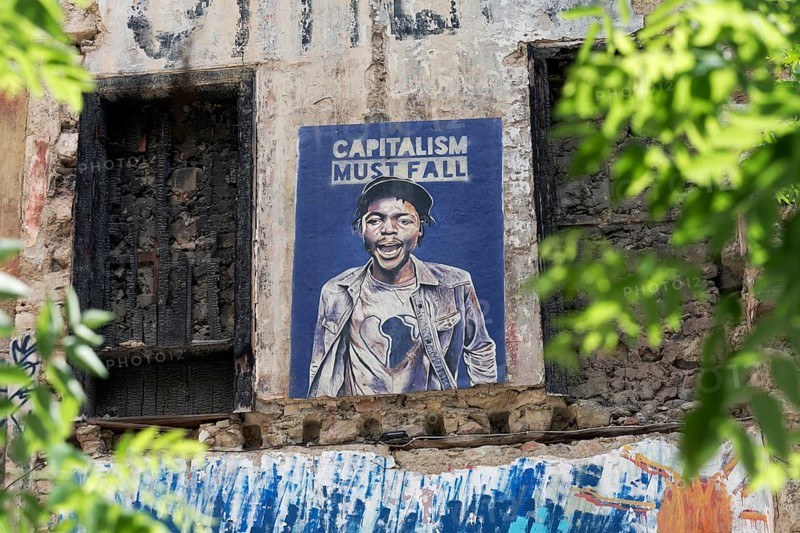 Poster critical of capitalism with a portrait of a coloured man in Exarchia, district of the students and alternative scene, Athens, Greece, Europe
