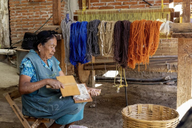 Teotitlan del Valle, Oaxaca, Mexico, Rural women in the Tlacolula Valley of Oaxaca benefit from a microfinance loan program run by the nonprofit En Via Foundation. Women can get interest-free loans starting at 1500 pesos ($75 US) to start or expand a business. The organization also gives classes in business basics, English, and internet marketing. Microloan recipient Margarita Chavez cards the wool she will use in her weaving, Central America