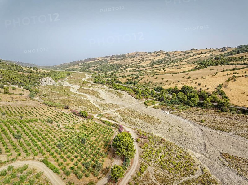 The dry riverbed of the Canale Raia, which is fed by the Torrente del Ferro torrent with water from the mountains after heavy rainfall. Aerial photo. Amendolara, Cosenza, Calabria, Southern Italy, Southern Europe