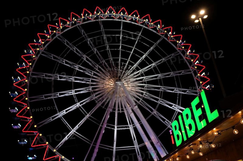 Night shot, sales stand for Bibles, religion, neon sign, Ferris wheel, Bible, behind it Ferris wheel Europe wheel, rides, Cannstatter Wasen, fair, Bad Cannstatt, Stuttgart, Baden-Württemberg, Germany, Europe