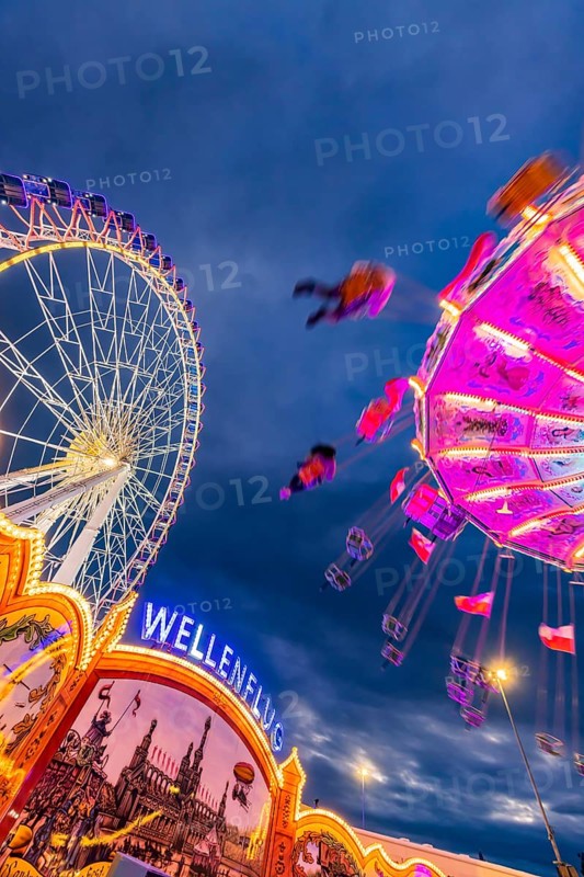 Chain carousel and Ferris wheel in the evening. 177th Cannstatter Volksfest at the Cannstatter Wasen. Bad Cannstatt, Stuttgart, Baden-Württemberg, Germany, Europe