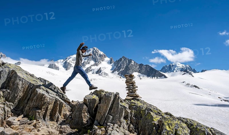 Mountaineer jumping from stone to stone, cairn, high alpine mountain landscape, Glacier du Tour, glacier and mountain peak, summit of Aiguille de Chardonnet, Chamonix, Haute-Savoie, France, Europe