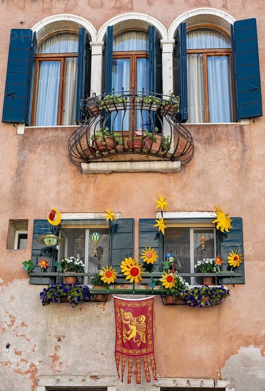Windows decorated with flowers on a house facade, Venetian flag, Venice, Veneto, Italy, Europe