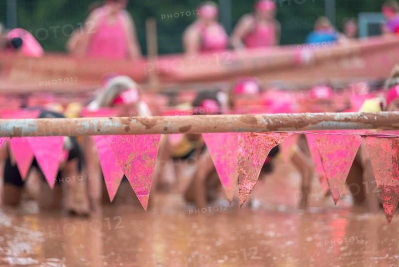 Group of participants in a muddy outdoor obstacle course