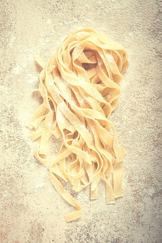 Raw tagliatelli pasta, homemade, top view, no people, rustic, food concept