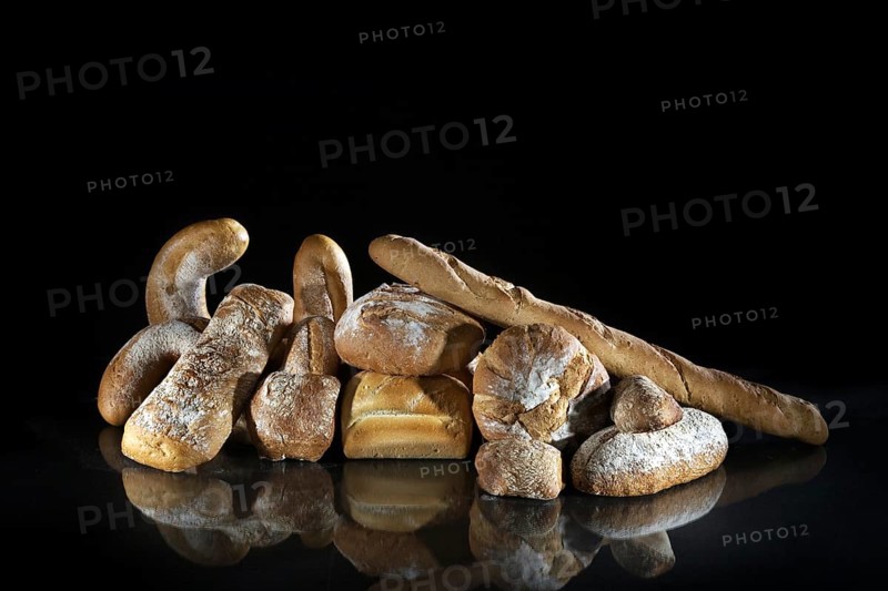 Assortment of different loaves of bread on black background