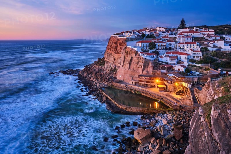 Scenic view of the seaside Azenhas do Mar fishing village on cliff on Atlantic ocean coast, Portugal in evening twilight dusk