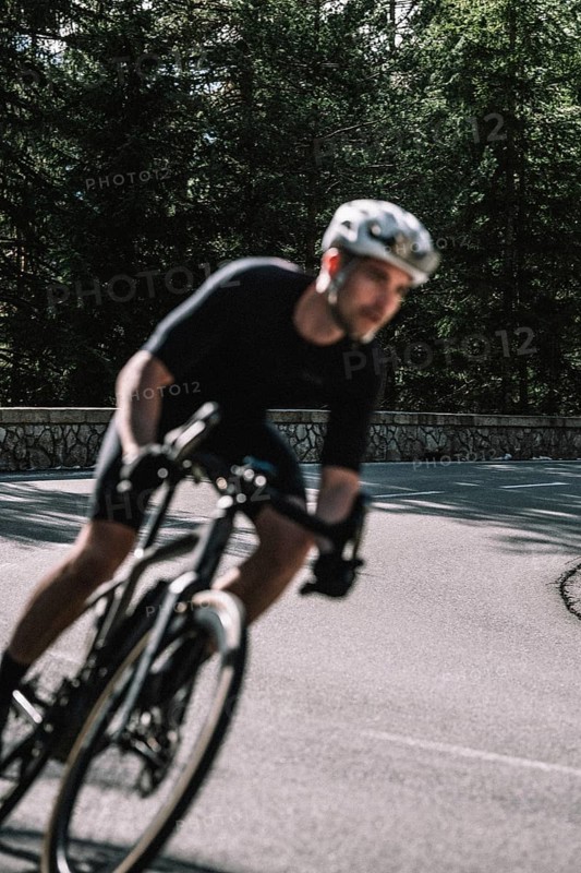 Road bike rider in spring between Lechtal and Tannheimer Tal in front of picturesque scenery of the Alps, Tyrol, Austria, Europe