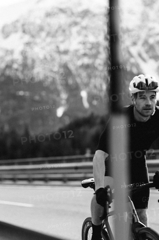 Road bike rider in spring in the Allgäu against the picturesque backdrop of the Alps, Bavaria, Germany, Europe