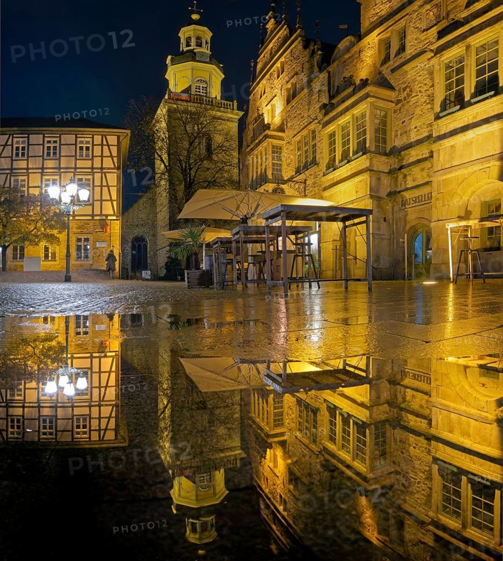 Town hall and church Marketplace illuminated Reflection in puddle Panorama Rinteln Germany