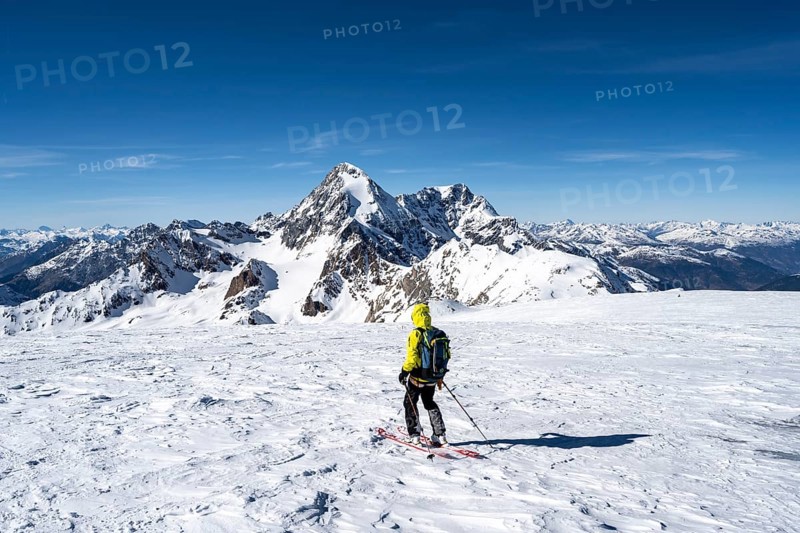 Ski tourers descending from the summit of Monte Cevedale on the Zufallferner, mountain panorama, snow-covered mountain landscape in winter, summit of the Königsspitze and Ortler in the background, Ortler Alps, Vinschgau Valley, Italy, Europe