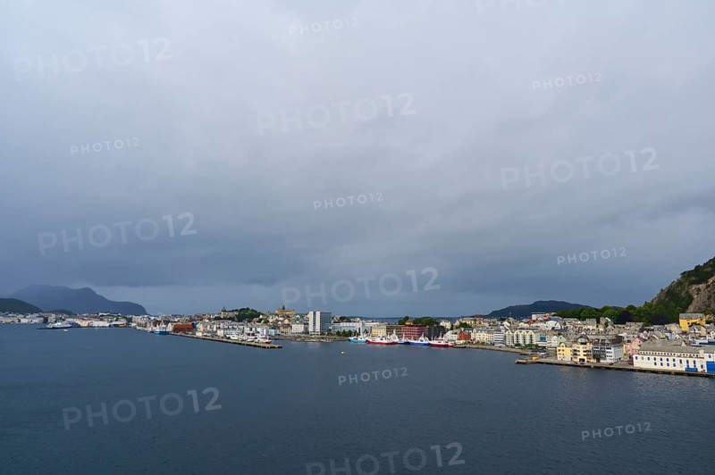 Coastal town by the sea with houses and hills in the background, boats in the harbour, cloudy sky, Alesund, Fylke, Norway, Europe