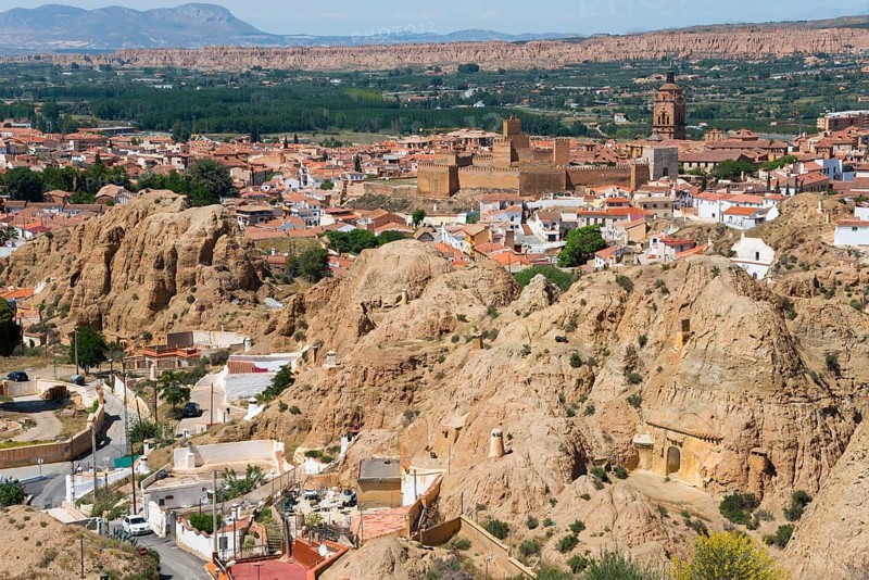 Traditional town embedded in a mountainous summer landscape under a blue sky, Alcazaba, Cathedral, Catedral de la Encarnación de Guadix, view from the Mirador del Cerro de la Bala, cave dwellings, cave district, Troglodytos, Barrio de Cuevas, Guadix, Province of Granada, Andalusia, Spain, Europe