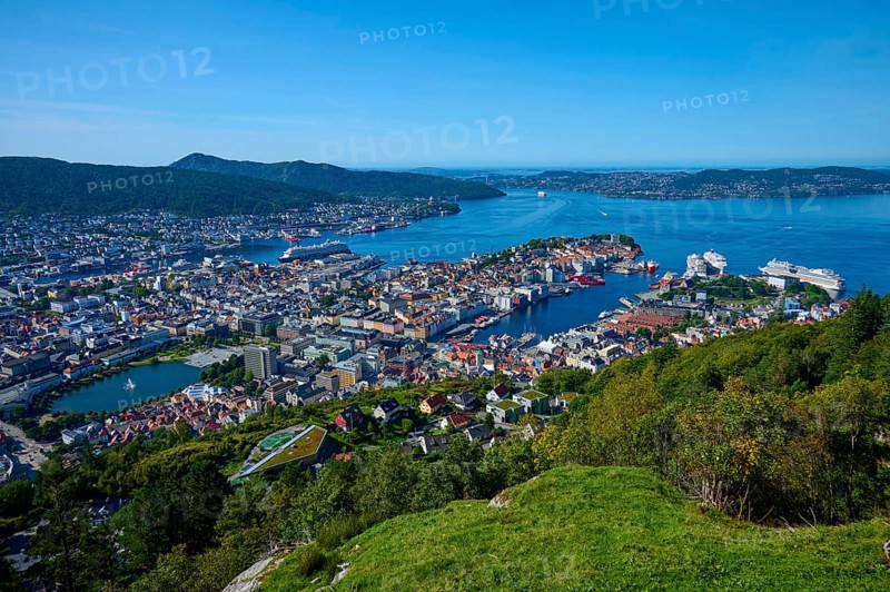 Panoramic view of a coastal town with harbour and a variety of buildings, surrounded by mountains and water under a clear sky, Fløibanen mountain station, Bergen, Vestland, Norway, Europe