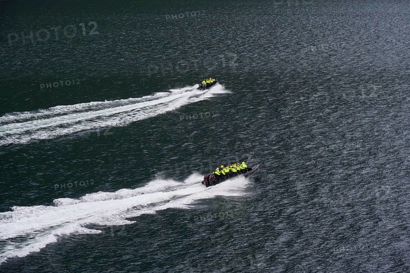 Two speedboats with groups of people travelling fast in the Geiranger Fjord, white waves are coming up behind them, Geiranger, Geiranger Fjord, Stranda, Romsdal, Norway, Europe
