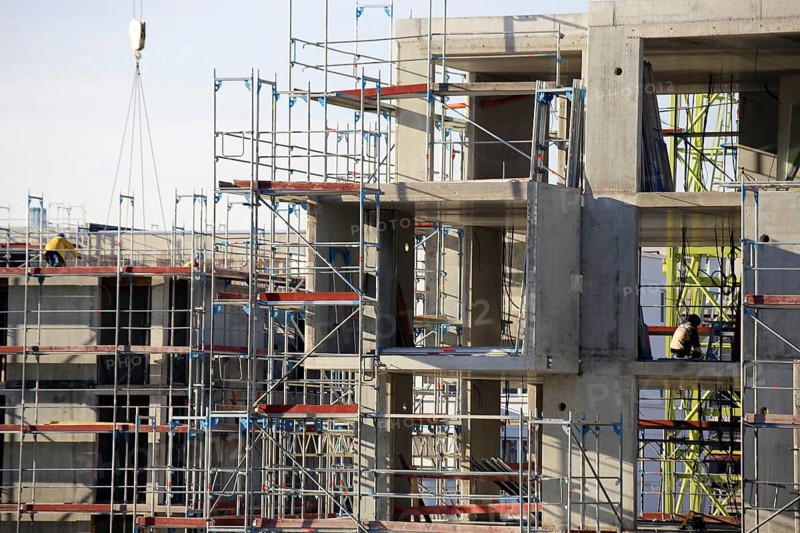 Photo of a large construction site in a newly developed residential area. Several apartment buildings are still under construction