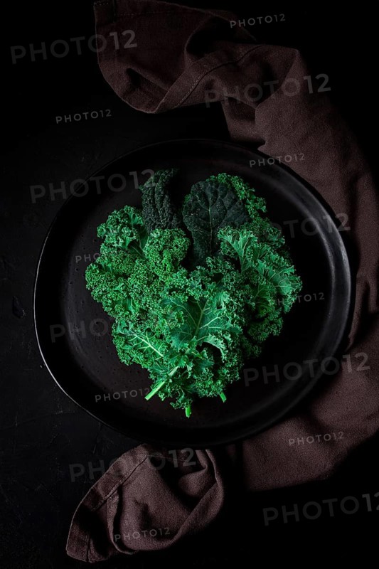Food background, on a black table, top view, Fresh Kale leaves, close-up, vertical, no people, toned. selective focus