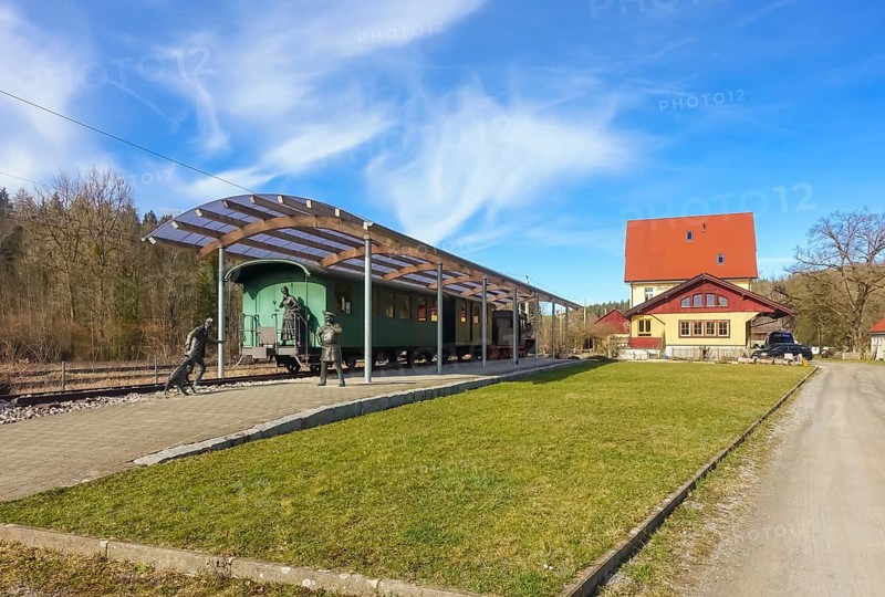 Durlesbach railway station, opened in 1849 and decommissioned in 1984, railway monument, railway memorial, group of figures by the artist René Auer, group of sculptures, scene from the song Auf de schwäbische Eisebahne, billy goat, woman, farmer, conductor, s Bäuerle, Konduktör, s Weible, bronze figures, Königlich Württembergischen Staats-Eisenbahnen, station building at the back right, Durlesbach, Reute, Bad forest lake, Upper Swabia, Baden-Württemberg, Germany, Europe