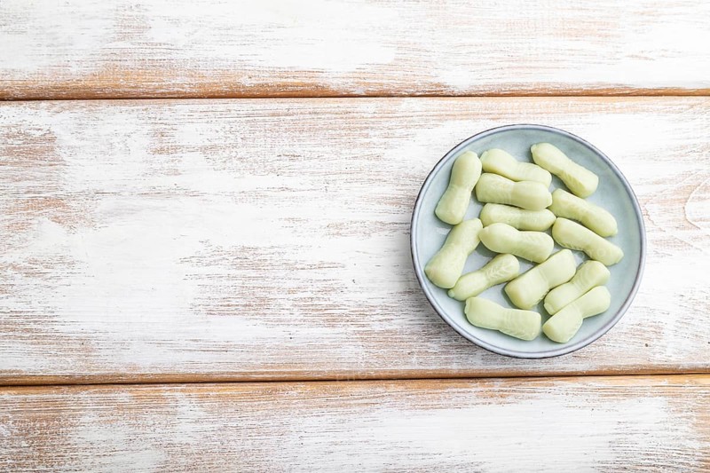 Jelly celery candies on white wooden background. copy space, top view, flat lay