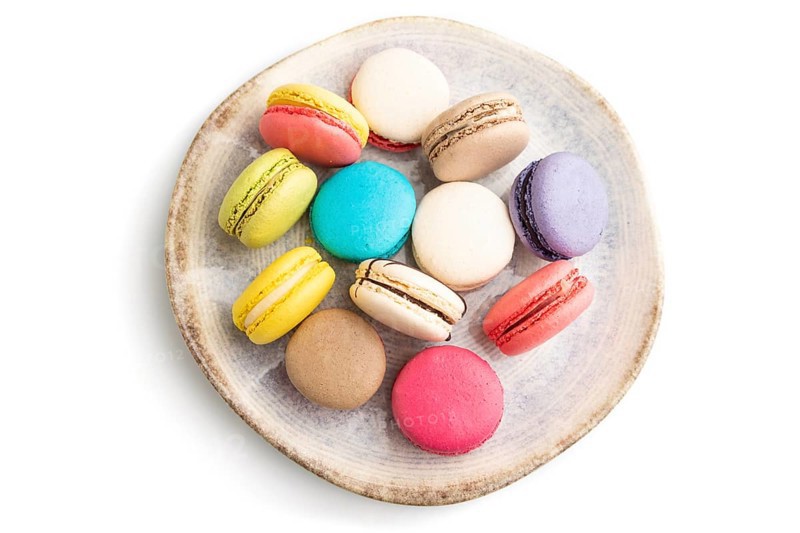 Multicolored macaroons on ceramic plate isolated on white background. top view, still life, flat lay, close up. Breakfast, morning, concept