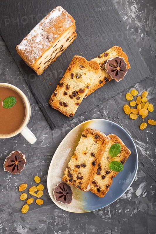Homemade cake with raisins, dried persimmon and a cup of hot chocolate on a black concrete background. top view, flat lay, copy space