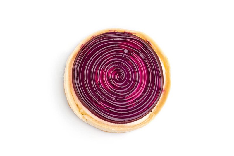Single sweet tartlet with jelly and milk cream isolated on white background. Top view, close up