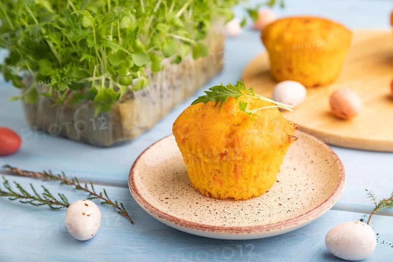 Homemade cakes with chocolate eggs and mizuna cabbage microgreen on a blue wooden background. side view, close up, selective focus