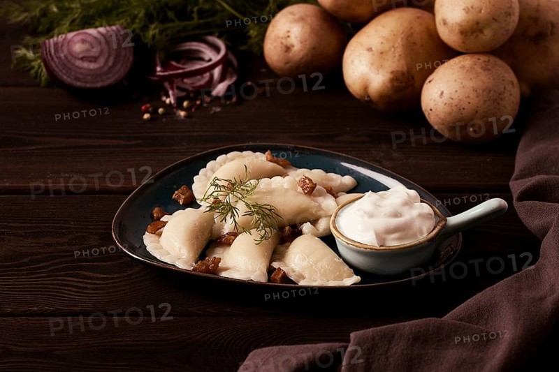 Traditional Polish dish, dumplings with potatoes, on a wooden table, close-up, with ingredients, no people