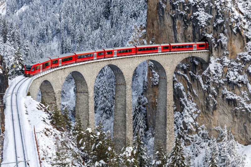 Rhaetian Railway train at the famous Landwasser Viaduct on the Albula railway Stadler Rail passenger train in Filisur, Switzerland, Europe
