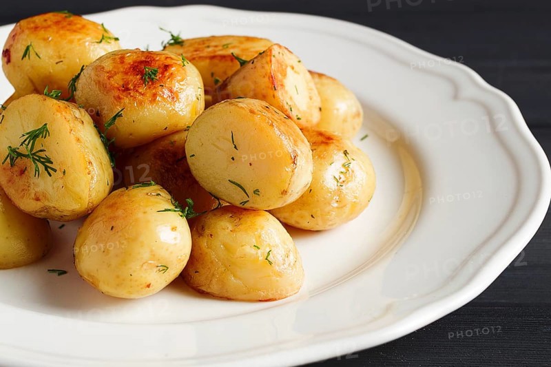 Fresh Cooked, new potatoes, with dill, on a wooden table, selective focus. close-up, toning, no people