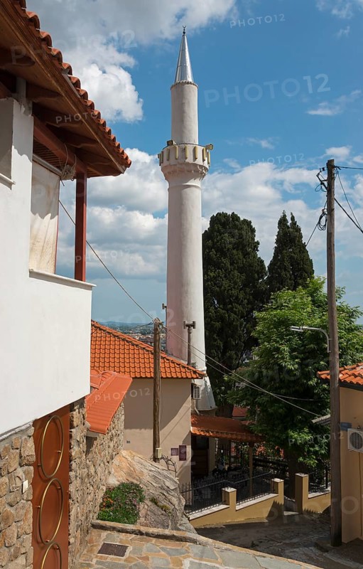 A white minaret rises against a blue sky next to traditional buildings, Xanthi, Eastern Macedonia and Thrace, Greece, Europe