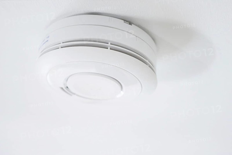 Symbolic photo on the subject of smoke alarms. A smoke detector hanging from the ceiling in a flat. Berlin, 21.08.2024
