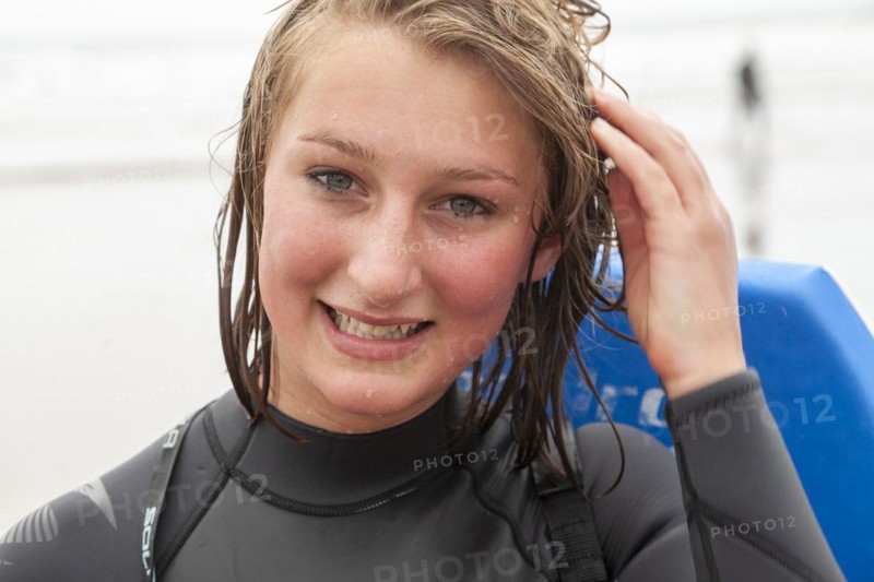 Teenage girl with wet face and hair close up portrait wet after swimming outdoors, UK -model released