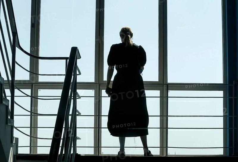 A woman stands at a window in a stairwell, Berlin, 26/06/2024, Berlin, Berlin, Germany, Europe