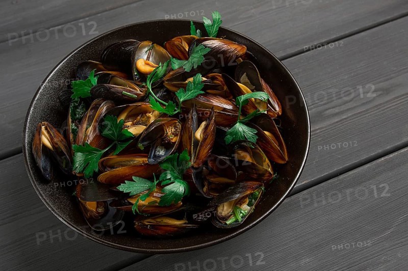 Fresh, Boiled mussels, Black Sea, with parsley and lemon, on a wooden table, no people