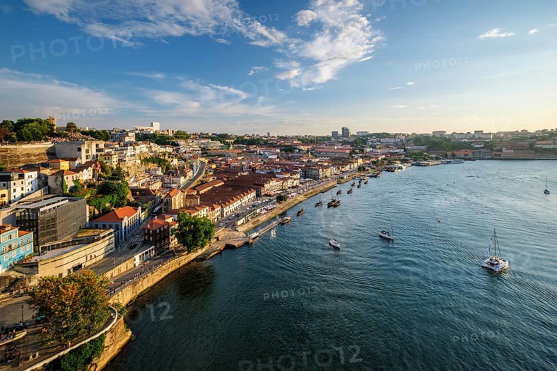 View of Vila Nova de Gaia city and Douro river with tourist boats on sunset. Porto, Portugal, Europe