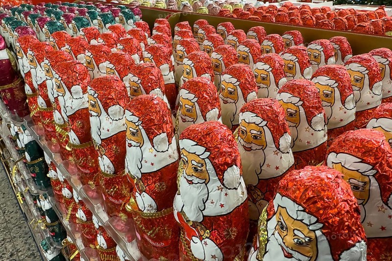 Display in shelf of wholesale of chocolate Father Christmases chocolate Father Christmases Father Christmas Father Christmas chocolate Father Christmases in colour red of red staniol paper of chocolate brand Lindt arranged like army of Father Christmas, Germany, Europe