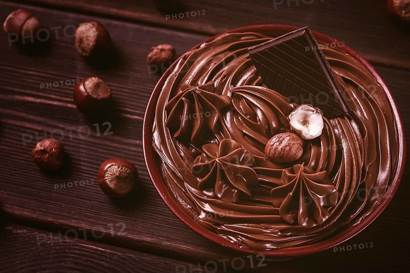 Chocolate nut paste, mousse, pasta, in a cup, on a wooden table, top view, selective focus, no people