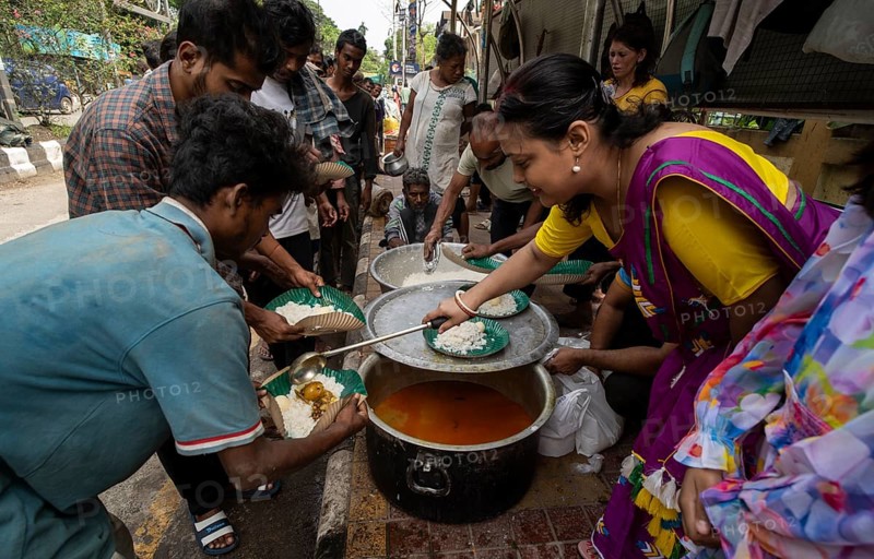 Homeless people stand in a queue as volunteers distribute food along a roadside, on October 11, 2024 in Guwahati, India. Poverty and hunger remain significant challenges in India, despite the country's rapid economic growth in recent decades