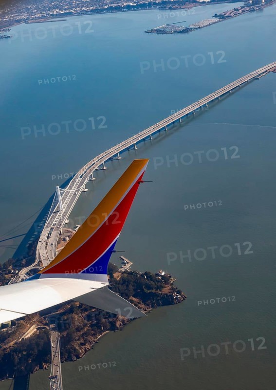 San Francisco, California, A Southwest Airlines plane flies over Yerba Buena Island and the San Francisco-Oakland Bay Bridge