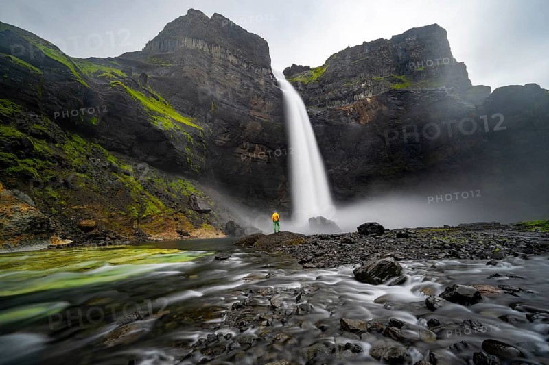 Young man with yellow jacket standing in front of waterfall, Haifoss and Granni waterfall at a canyon, Fossá í Þjórsárdal, with river í Þjórsárdal, long exposure, dramatic landscape, Hekla, Iceland, Europe