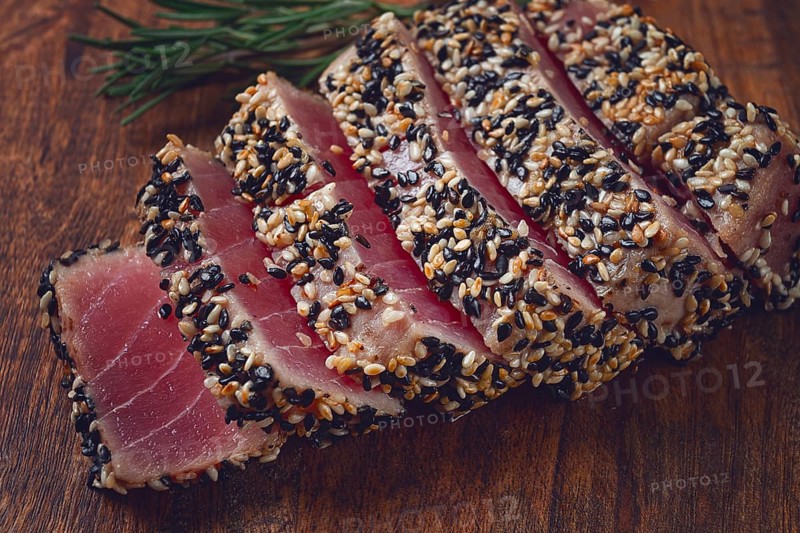 Fillet of red tuna meat, fried in sesame seeds, homemade, close-up, no people, on a wooden background