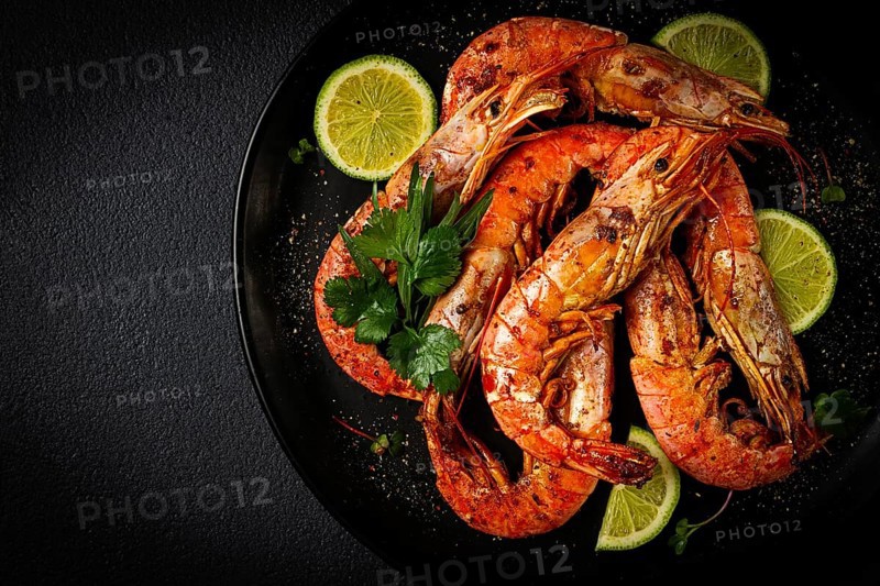 Langoustines, Australian, freshly frozen on ice, top view, lime and greens